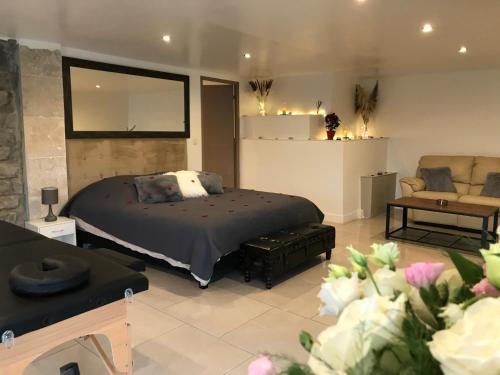a bedroom with a bed and a couch and a chair at Love Room Villa Charlene in Massoins