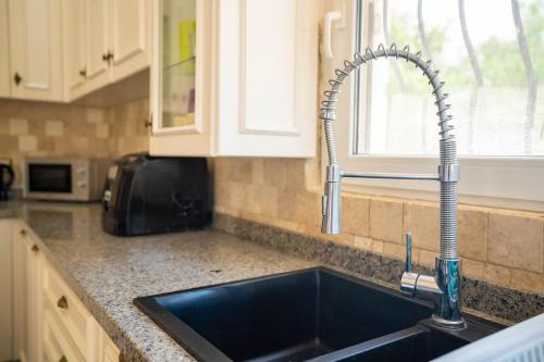 a kitchen counter with a sink and a window at Poolside Bar Villa Sea Views atalky in Klepini
