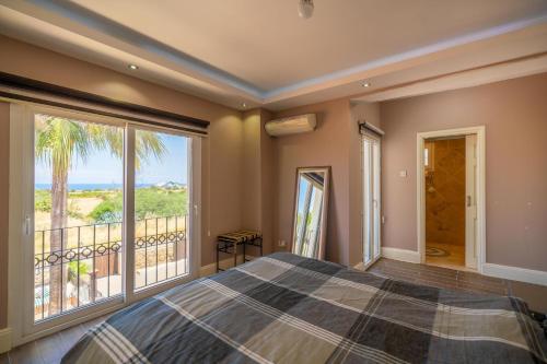 a bedroom with a bed and a view of the ocean at Poolside Bar Villa Sea Views atalky in Klepini