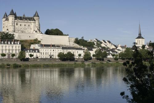 a large castle sitting next to a body of water at Hôtel Anne d'Anjou, The Originals Collection in Saumur