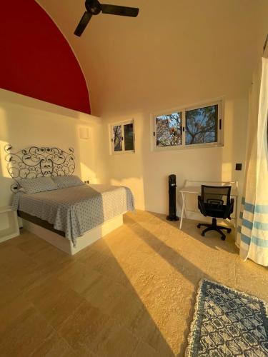 ein Schlafzimmer mit Bett, Schreibtisch und Fenstern in der Unterkunft Milky Way in San Miguel del Puerto