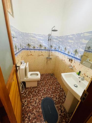 a bathroom with a toilet and a sink at Archwey Coco Ella in Ella