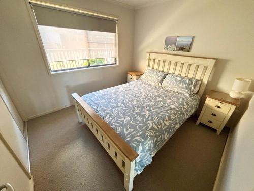 a small bedroom with a bed and a window at Jubilee Apartment 04 - Bring your own linen in South West Rocks