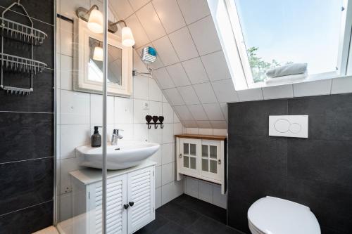 a bathroom with a sink and a toilet and a window at Möhlenblick in Neustadt in Holstein