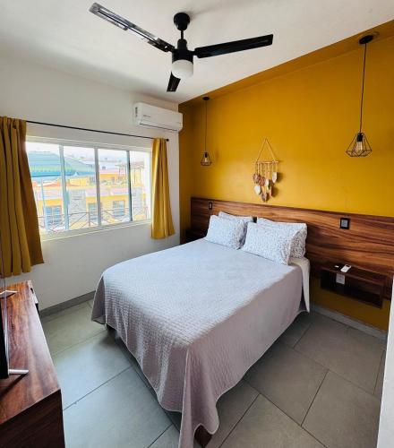 a bedroom with a bed with a yellow wall at Casa Bugambilias 3 tercer piso in La Peñita de Jaltemba