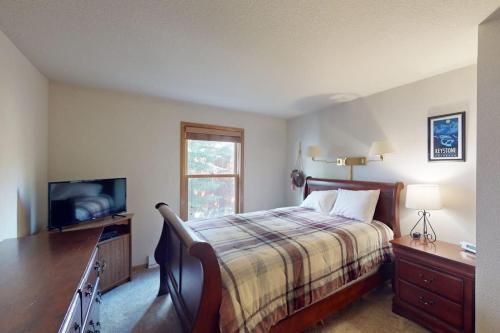 a bedroom with a bed and a flat screen tv at Snowdance Manor 205 in Keystone