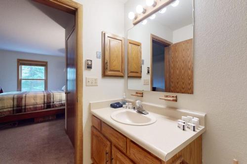 a bathroom with a sink and a mirror and a bed at Snowdance Manor 205 in Keystone