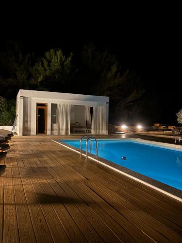 a villa with a swimming pool at night at Beach House Mostir in Ugljan