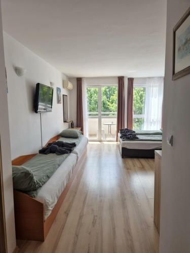 a bedroom with two beds and a television on the wall at Studio Kasandra in Hisarya