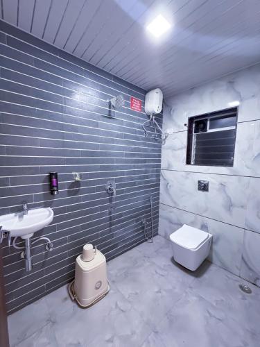 a bathroom with a sink and a toilet at Advik Resort in Badlapur