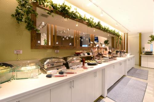 a kitchen with a counter with food on it at Vessel Inn Hiroshima Station in Hiroshima