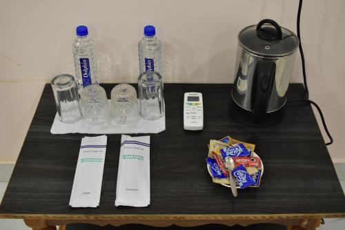 a table with bottles of water and a coffee maker at Bhitarkania Riverside Eco Resorts in Righāgarh