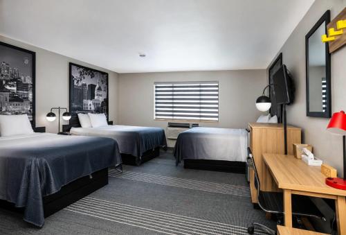 a hotel room with two beds and a flat screen tv at Super 8 by Wyndham Warrenton in Warrenton