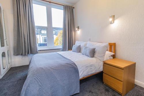 a bedroom with a large bed and a window at Free Parking, Entire 8 Ensuite Bedroom Townhouse, Fully Equipped Kitchen, Dining Room & Lounge, Perfect for Family Gatherings, Long Term Contractor, Relocation, etc Stays, 15 mins to Nissan, 20 mins to Sunderland & Newcastle, See our Site for Assurance in South Shields