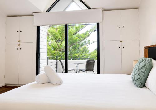 a bedroom with a large white bed with white cabinets at Esplanade Views Heart of Freo Family Stay in Fremantle