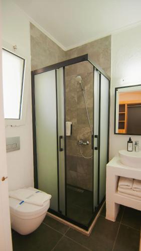 a bathroom with a shower and a toilet and a sink at Costa Sariyaz Hotel Bodrum in Bodrum City