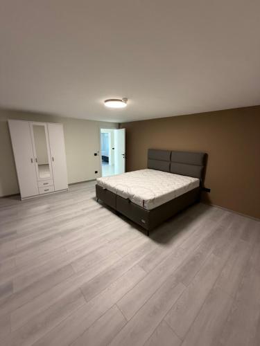 a bedroom with a bed and a wooden floor at Vila Handžić in Mostar