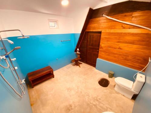 a bathroom with a toilet and a wooden wall at That's Why Nilaveli Beach Cabanas in Trincomalee