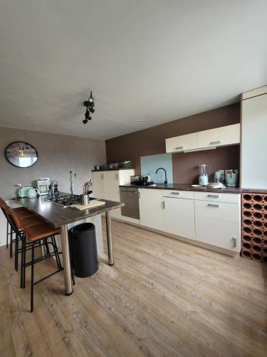 a large kitchen with a table and a counter top at L'Annexe de Steph in Loulans-Verchamp