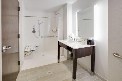 a white bathroom with a sink and a shower at Wingate by Wyndham San Angelo in San Angelo