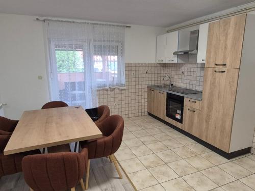 a kitchen with a table and chairs in a room at Apartment LIKA in Gospić