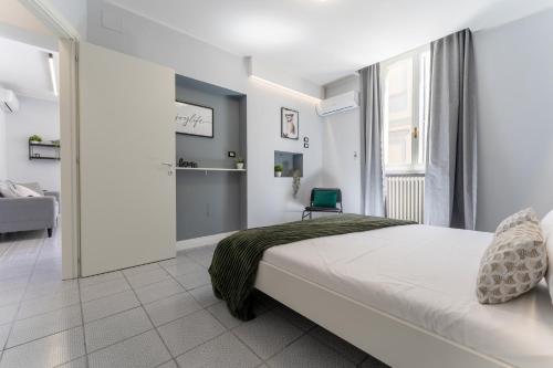 a white bedroom with a bed and a window at Bandiera Urban House in Lanciano