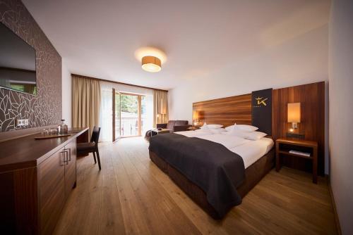 a hotel room with a large bed and a bathroom at Das Kronthaler - Adults only in Achenkirch