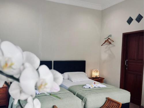 a bedroom with a bed and flowers in it at Noble Bali Diving Resort Tulamben in Tulamben