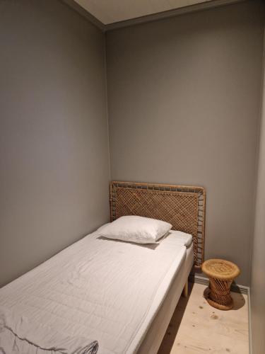 a small bedroom with a bed and a stool at Sjöstugan in Leksand