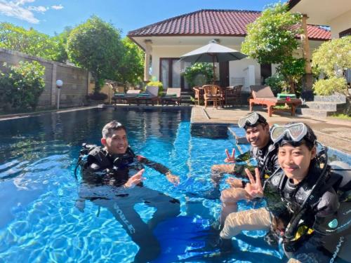 three men in the water in a swimming pool at Noble Bali Diving Resort Tulamben in Tulamben