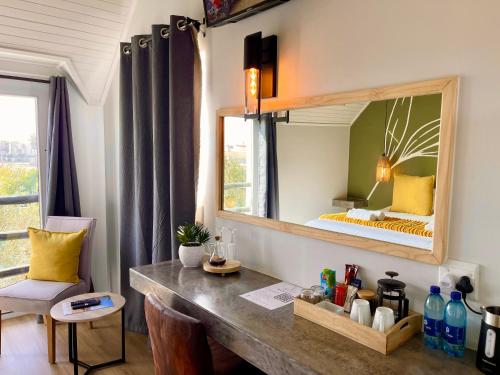 a bedroom with a large mirror and a bed at Olive Tree Boutique Guesthouse in Swakopmund
