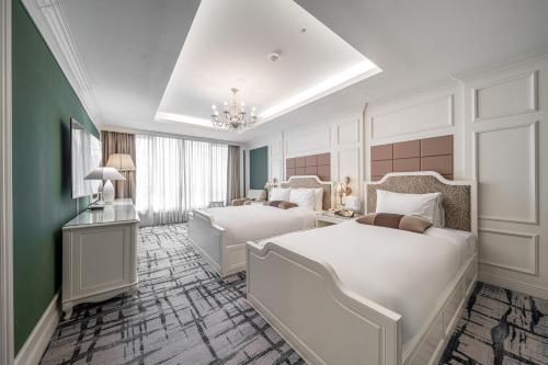 ein Schlafzimmer mit zwei Betten und einem Kronleuchter in der Unterkunft Koreana Hotel in Seoul