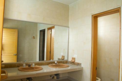 a bathroom with two sinks and a large mirror at Prima verde in La Serena