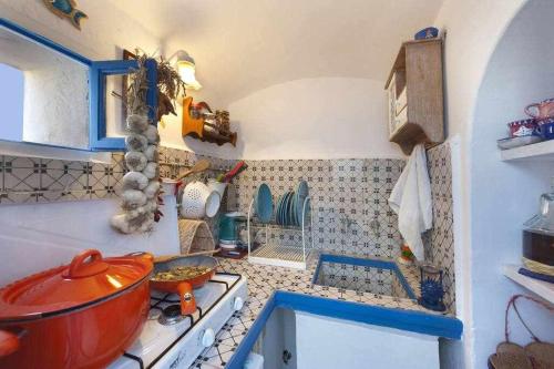 a kitchen with a red pot on the stove at The Sirens House in Nerano