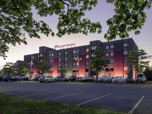 a hotel with cars parked in a parking lot at Fürther Hotel Mercure Nürnberg West in Fürth
