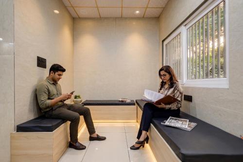 a man and a woman sitting in a waiting room at FabHotel Shivangan in Vrindāvan