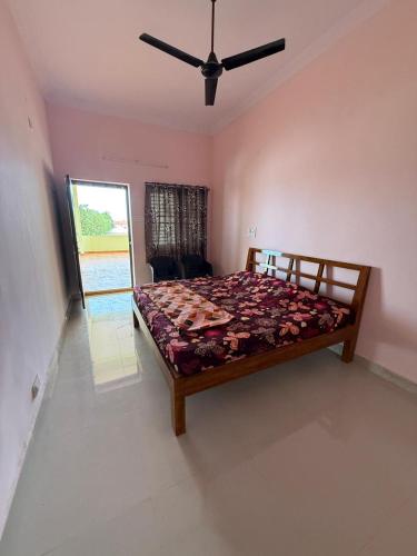a bedroom with a bed and a ceiling fan at Sagara Darshanam in Vetāpālem