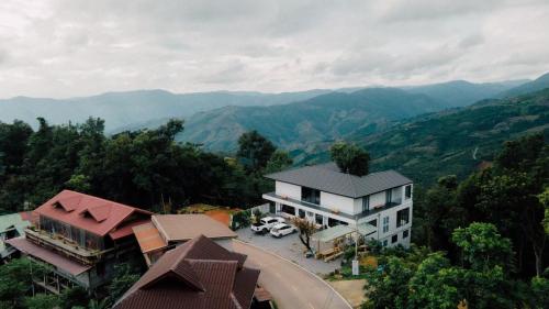an aerial view of a house with mountains in the background at Mei Nai Home เมย นาย โฮม in Ban Sakat Nua