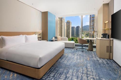 a bedroom with a large bed and a living room at Hilton Wenzhou in Wenzhou
