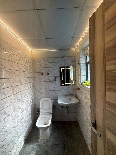 a bathroom with a toilet and a sink at Ballentines Bliss in Babarpur