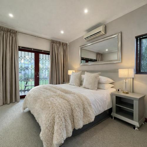 a bedroom with a large bed and a mirror at Oak & Ivory - Uitzicht in Oakdale