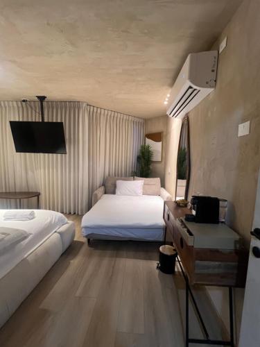 a bedroom with two beds and a television in it at Kohav Sea View Penthouse in Eilat