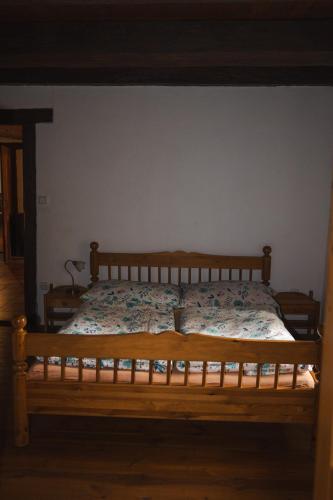 a bed in a bedroom with a wooden frame at Statek VRANČ - U Kačenky in Bítov