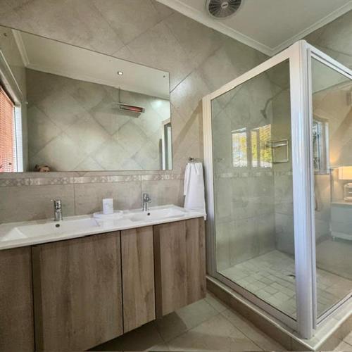 a bathroom with a shower and a sink and a mirror at Oak & Ivory - Uitzicht in Oakdale