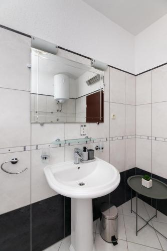 a white bathroom with a sink and a mirror at APARTMENT MARCELA SUTIVAN - large two-bedroom apartment with two bathrooms - excellent location right by the town center and the beach - parking space provided - panoramic view of the sea and the town in Sutivan