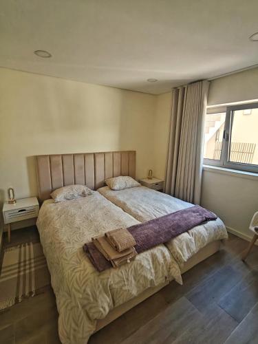 a bedroom with a large bed with two towels on it at Refugio do Surf Cortegaça in Cortegaça