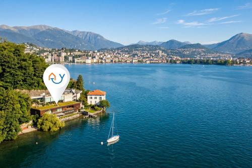 an aerial view of a lake with a boat and a balloon at Maison Sur l'Eau - Lugano Villa with View Terrace in Paradiso