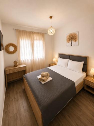 a bedroom with a bed with a tray with towels on it at Vigla summer house! in Paralia Sikias