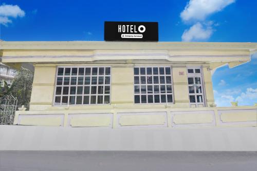 a yellow building with a sign on top of it at Hotel O Ghoom Formerly Aps Homestay in Darjeeling