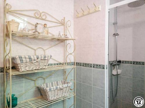 a bathroom with shelves with baskets and a shower at Montmajou in Cier-de-Luchon